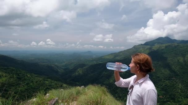 女性ハイカーが冷たい水を飲む景色を楽しむ - 映像、動画