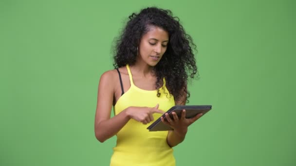 Young beautiful Hispanic woman using digital tablet and getting good news - Materiaali, video