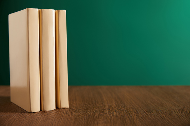 trois livres sur table en bois avec tableau sur fond
 - Photo, image