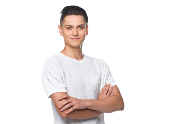 handsome smiling man standing with crossed arms in white shirt isolated on white  - Fotó, kép