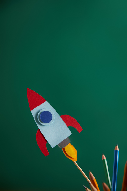 pencils and colorful rocket with green chalkboard on background - Photo, Image