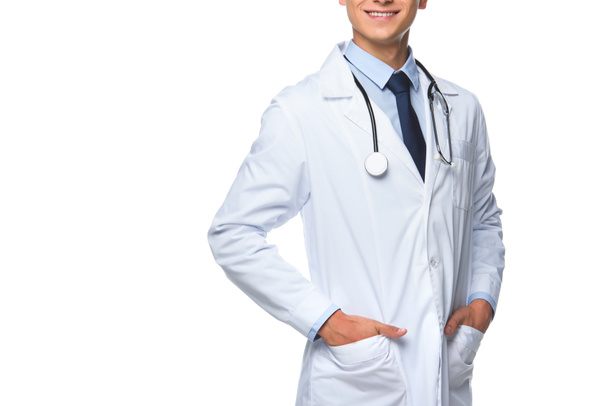 cropped shot of young doctor with hands in pockets of medical coat isolated on white - 写真・画像