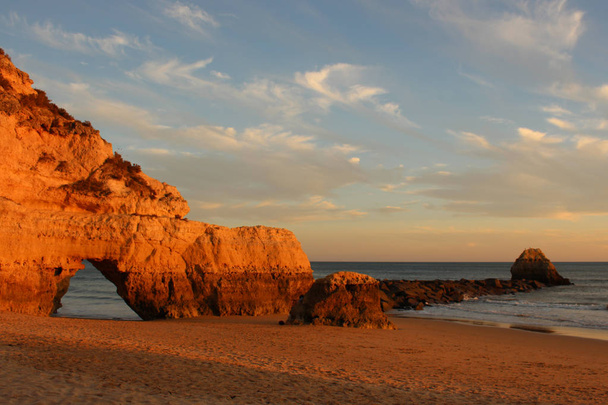 Захід сонця над скелі на пустельний пляж (в Алгарве, Португалія) - Фото, зображення
