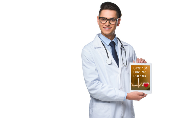handsome young doctor holding tablet with heart rate monitor on screen isolated on white - Photo, Image