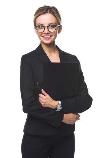 smiling young businesswoman holding clipboard and looking at camera isolated on white - Φωτογραφία, εικόνα