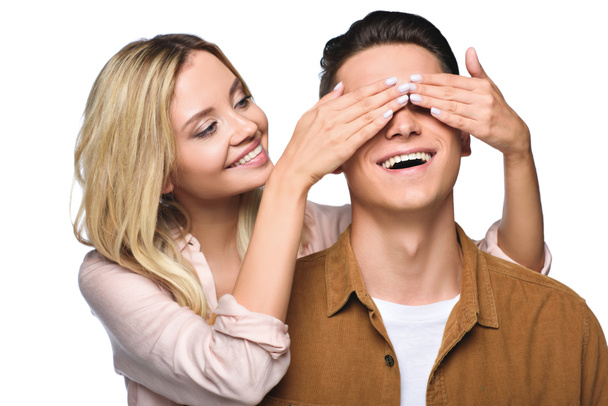 happy young woman covering her boyfriends eyes from behind isolated on white - Фото, изображение