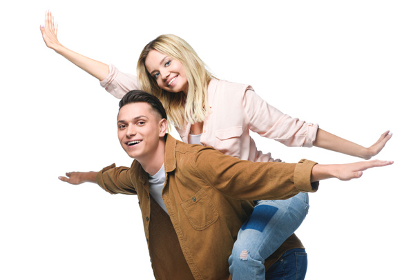 young happy woman piggybacking on boyfriends back and looking at camera isolated on white - Foto, Bild