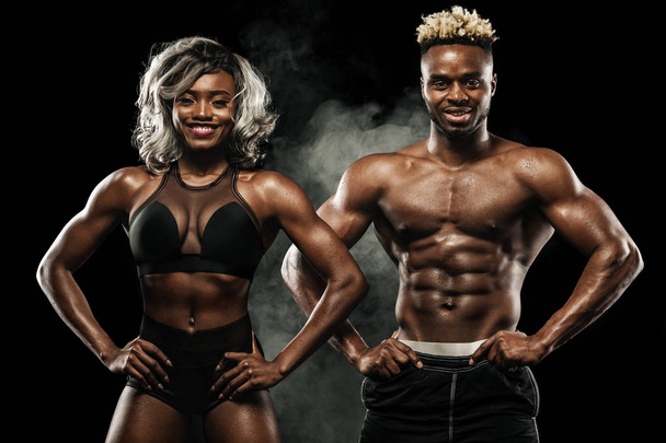 Фитнес-пара спортсменов позируют на черном фоне, здоровый образ жизни уход за телом. Спортивная концепция с копировальным пространством
. - Фото, изображение