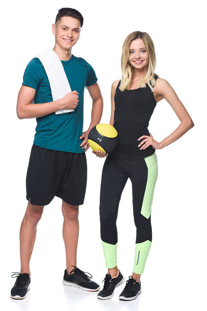 joven pareja atlética con fitball y toalla mirando a la cámara aislada en blanco
 - Foto, Imagen