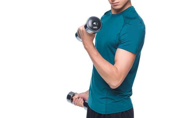 cropped shot of young sportsman exercising with dumbbells isolated on white - Φωτογραφία, εικόνα