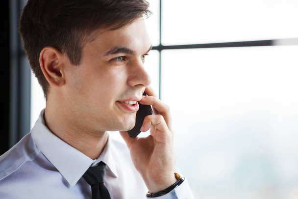 Portrait of young handsome businessman talking on the phone. - Zdjęcie, obraz