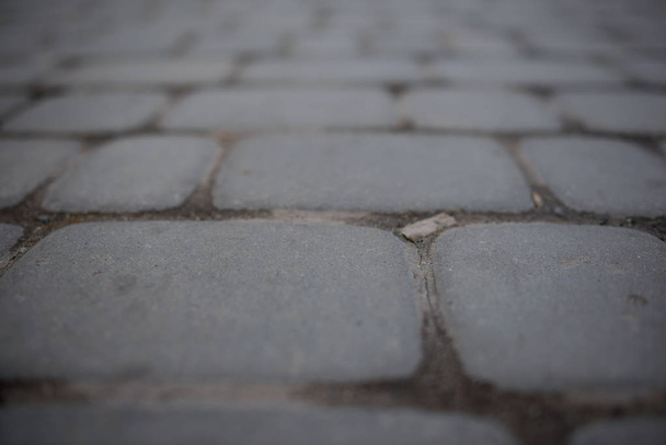 Perspectief-uitzicht op Monotone grijze bakstenen Stone Street weg. Stoep, trottoir textuur achtergrond - Foto, afbeelding