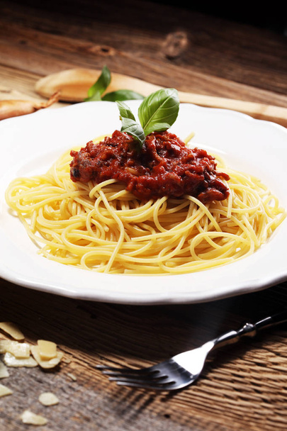 Teller mit köstlichen Spaghetti Bolognaise oder Bolognese mit herzhaftem Rinderhackfleisch und Tomatensauce garniert mit Parmesan und Basilikum - Foto, Bild