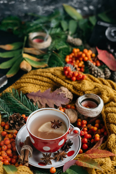  Flat lay view of autumn leaves,candles  and textured scarf on wooden background with cup of tea . Autumn or Winter concept. - Fotografie, Obrázek