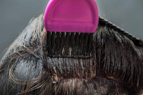 Πεθαίνουν τα ξανθά μαλλιά σε μαύρο χρώμα με ροζ brush - Φωτογραφία, εικόνα