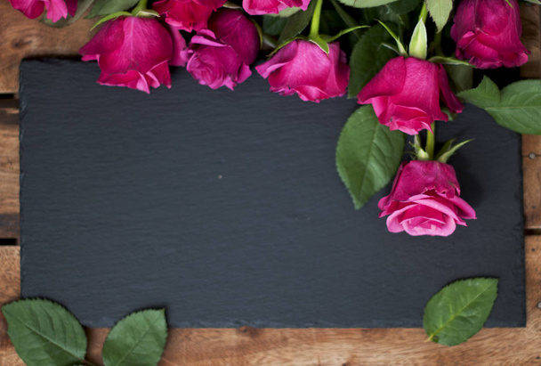 fresh roses with foliage on a wooden background - Photo, image