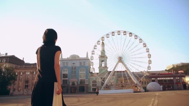 nainen kävelee maailmanpyörän torilla
 - Materiaali, video
