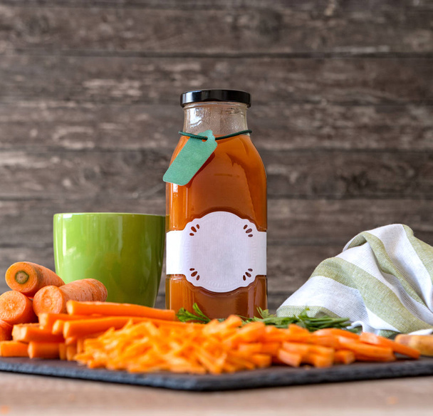 nutrient organic carrot juice in bottle on the table - Fotó, kép