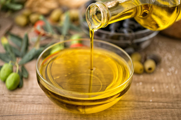 bottle virgin extra olive oil of pouring in glass bowl - Φωτογραφία, εικόνα