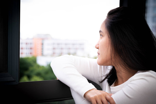 κατάθλιψη γυναίκες κάθονται κοντά σε παράθυρο, μόνο, θλίψη, συναισθηματική έννοια - Φωτογραφία, εικόνα