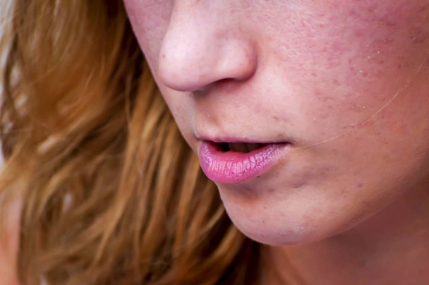 Ένα κατώτερο μέρος του προσώπου του μια νεαρή γυναίκα, της μύτης και του στόματος απομονωμένες, close up εικόνα. Νεαρό κορίτσι μιλάμε έννοια. - Φωτογραφία, εικόνα