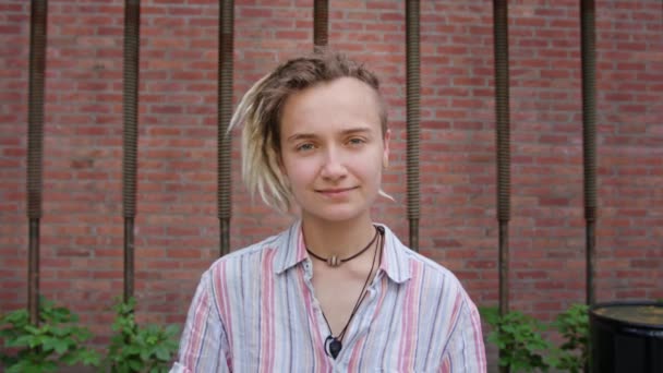 Fiatal hölgy Modern frizura pózol a szabadban - Felvétel, videó