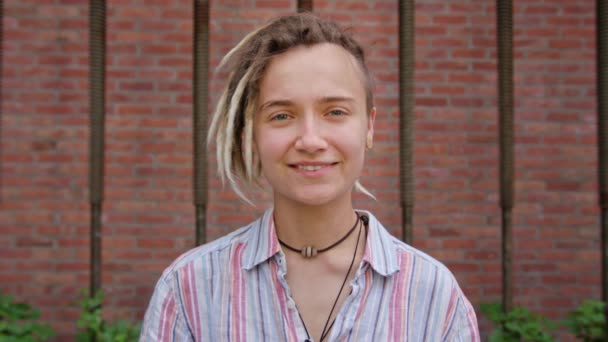 Młoda Pani z nowoczesną fryzurę uśmiechający się na zewnątrz - Materiał filmowy, wideo