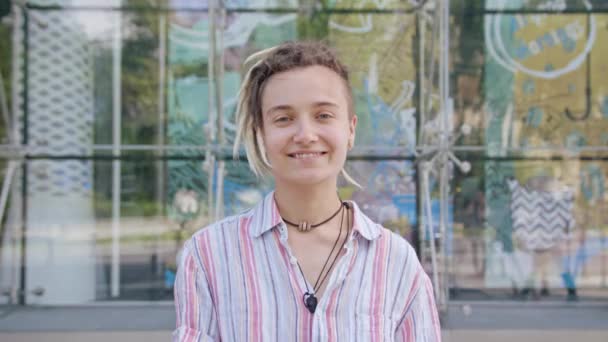 Fiatal hölgy Modern frizura mosolyogva a szabadban - Felvétel, videó