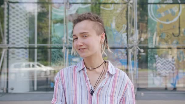 Jovem com penteado moderno sorrindo ao ar livre
 - Filmagem, Vídeo