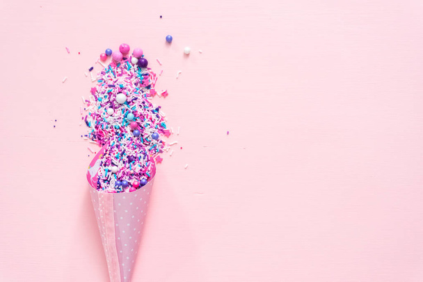 Colorful purple sprinkle blend on a pink background. - Photo, Image
