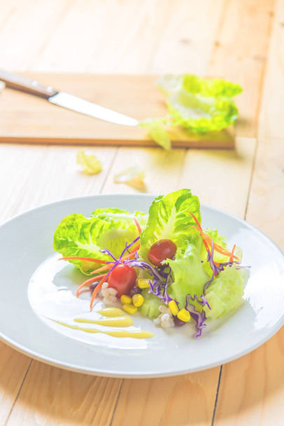 Image of Fresh healthy salad and empty wood Chopping board on wooden table.(vertical) - Photo, Image