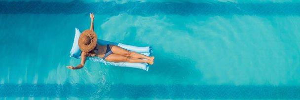 Απολαμβάνοντας ηλιοθεραπεία. Παραθεριστικές κατοικίες έννοια. Κάτοψη του slim νεαρή γυναίκα στο μπικίνι στο μπλε στρώμα αέρα, η μεγάλη πισίνα. Μεγάλη μορφή banner - Φωτογραφία, εικόνα