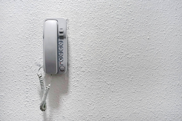 White wall phone. Intercom hung on a white wall. An object of home. White wall mounted contemporary entry phone system. Vintage wall Phone on white background. - Photo, Image