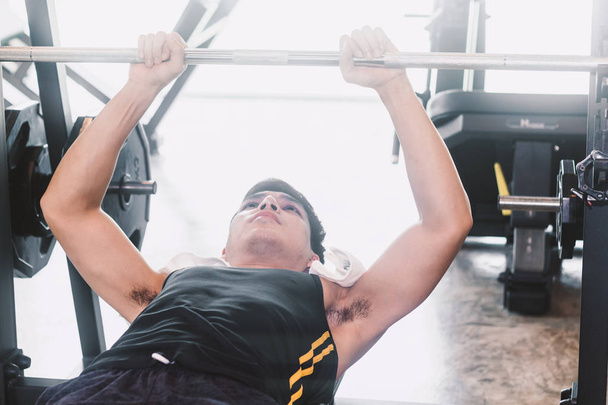 Hombre de fitness haciendo ejercicios de pesas con pesas sentado en el gimnasio
 - Foto, imagen