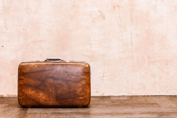 Vintage brown traveling luggage on wall background. Travel suitcases concept - Фото, изображение