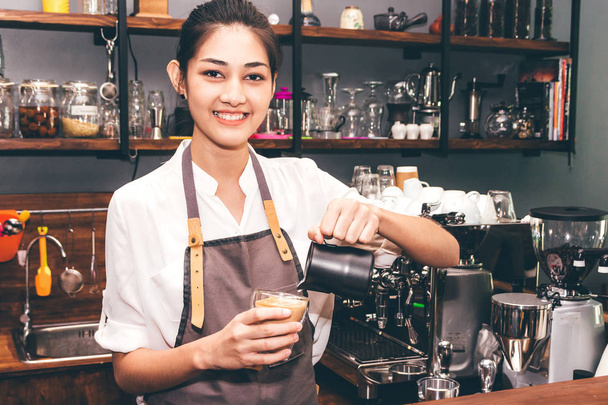 Barista holding milk for make coffee latte art in coffee shop - Photo, Image