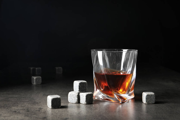 Glass with liquor and whiskey stones on table - Zdjęcie, obraz