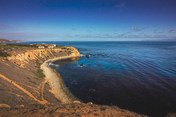 Elevated coastal view of Pelican Cove looking down at the rocky shoreline on a sunny day with Santa Catalina Island in the distance, Rancho Palos Verdes, California - Fotoğraf, Görsel