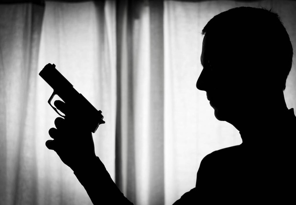 Homem em posição de alerta com uma arma na mão
 - Foto, Imagem