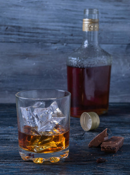 pullo ja lasi viskiä, jäätä ja suklaata
 - Valokuva, kuva