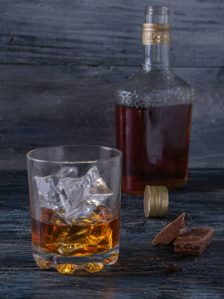 bir şişe, bardak viski ve buz ve çikolata - Fotoğraf, Görsel