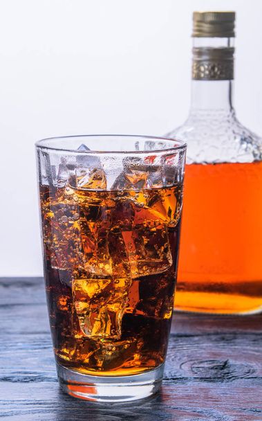 стакан льда и бутылку с напитком
 - Фото, изображение