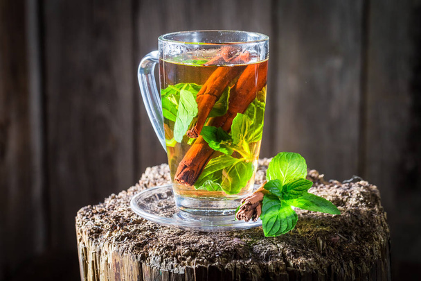 Aromatic and fresh tea with cinnamon bark and green leaves - Foto, imagen