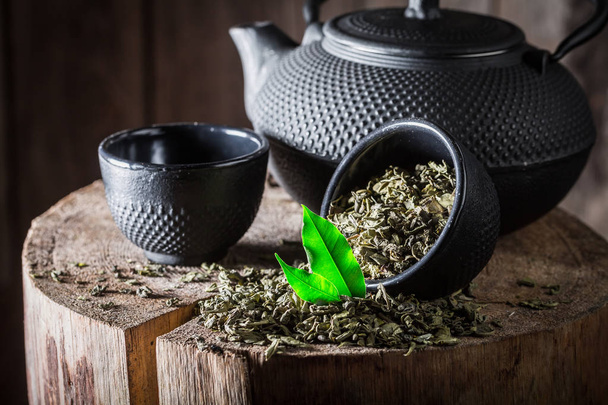 Gros plan de thé vert frais avec théière en fer et tasse
 - Photo, image