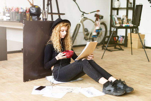 Curly Artist Sitting With Cup and Sketch - Foto, imagen