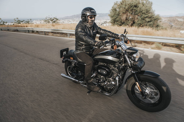 Malaga, Espanja - 15. heinäkuuta 2018: Mies ajaa Harley Davidson moottoripyörällään matkallaan Malagan vuoristoteiden ympäri Espanjassa
. - Valokuva, kuva