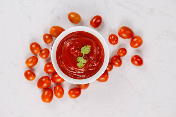 Чаша кетчупа и свежие помидоры на столе
 - Фото, изображение