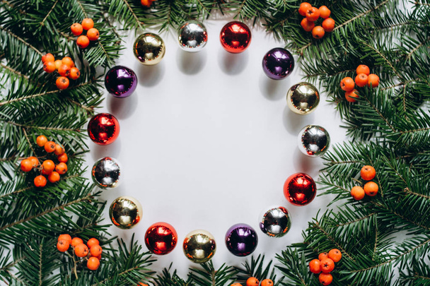 クリスマスの組成物。リースはクリスマス ツリーの枝と赤い実と白い背景の上のクリスマスのおもちゃから成っています。フラットを置く、上面図、コピー スペース、サークル - 写真・画像