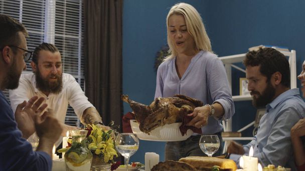 Woman serving holiday turkey on dinner with friends - Photo, Image