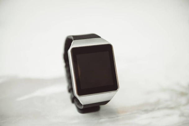 Unknown smart wrist watch on white table - Φωτογραφία, εικόνα